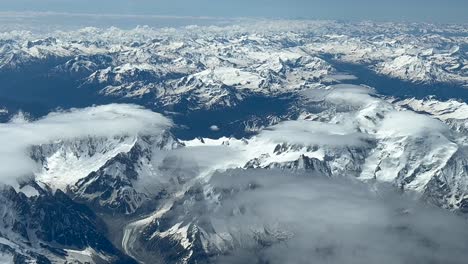 pov of the alps range, shot from an airplane cockpit while flying at 8000m high northbound