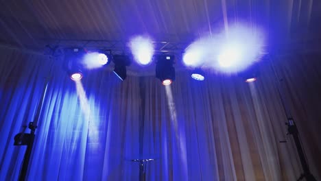 animation of stage lights frame. bright shiny lights flashing with blue from spotlight projectors in the dark. led lighting equipment.