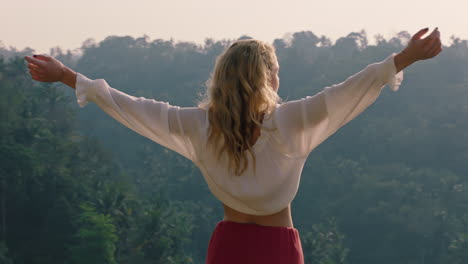 Mujer-Feliz-Celebrando-Con-Los-Brazos-Levantados-Mirando-La-Selva-Tropical-Al-Amanecer-Sintiendo-Alegría-En-La-Aventura-De-Las-Vacaciones-De-Verano-Disfrutando-De-Un-Nuevo-Día-En-El-Paraíso