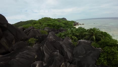 fpv drone flying on a anse source d'argent beach in seychelles on an island mahe, video of incredible trees, seychelles rocks, seaside, and surrounding seychelles landscapes