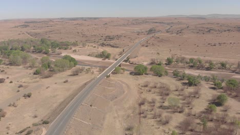 aerial shot circling a bridge covering a dry river