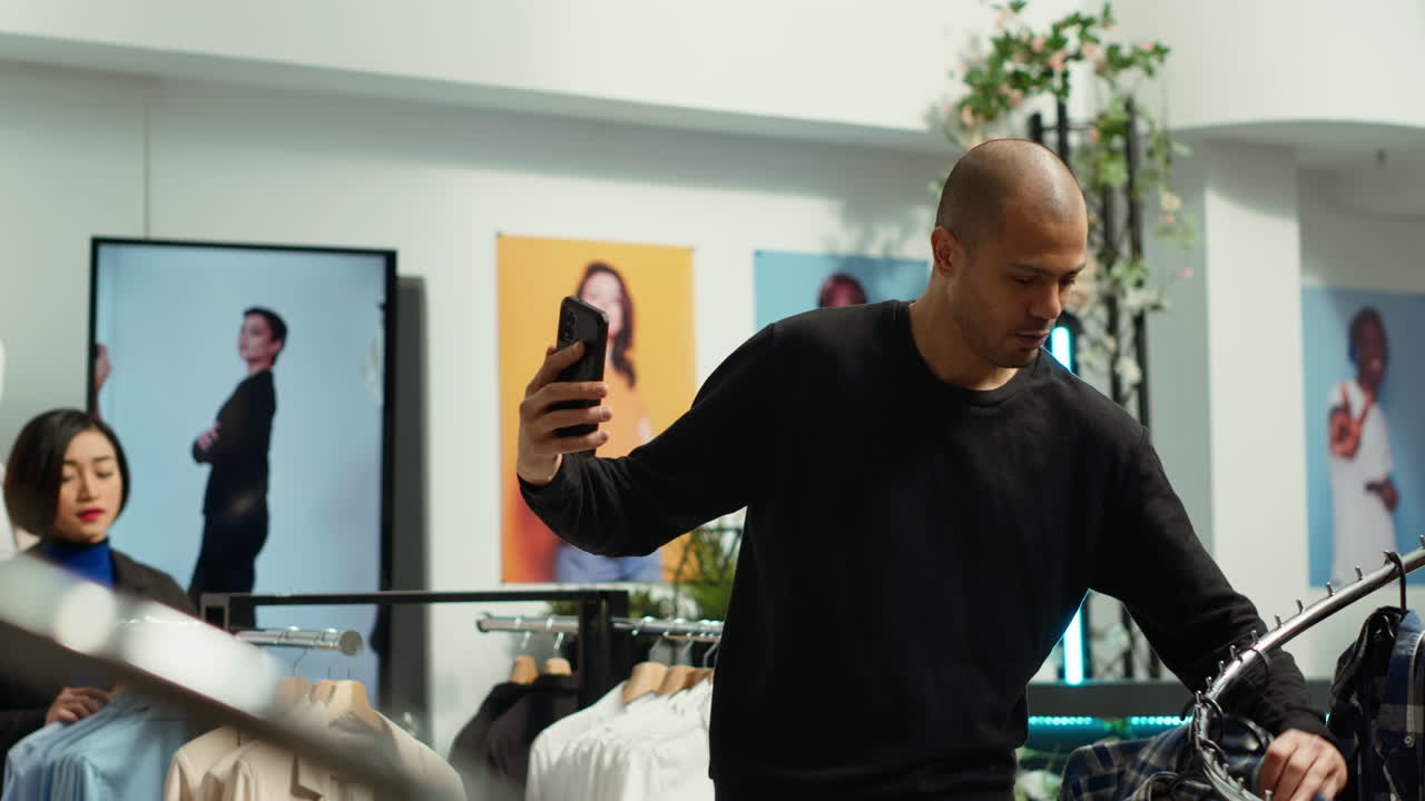 Man taking selfie while trying on clothes in a clothing store
