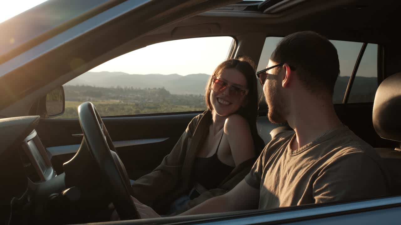 Side View of Young Couple on a Road Trip, Man and Woman Talk While Sitting in the Car, Travel Concept