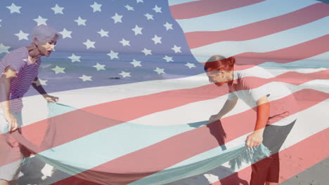 animation of american flag waving over senior couple spreading blanket on beach