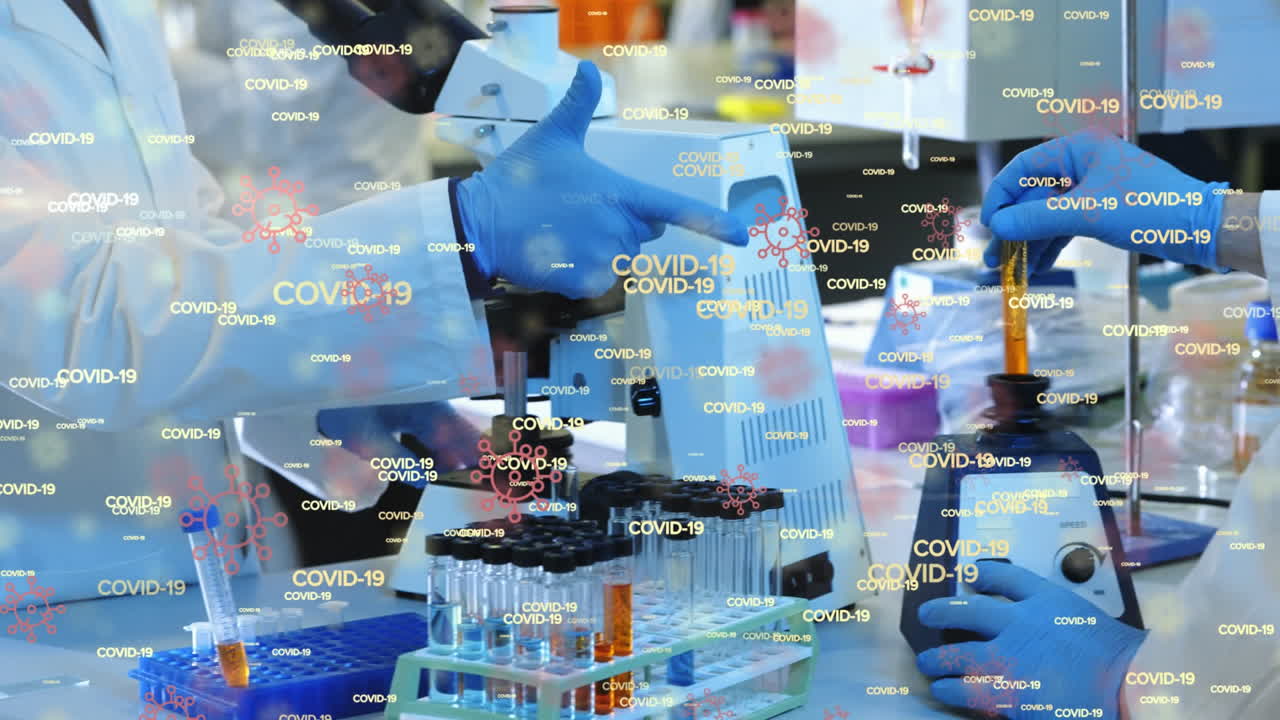 animación de palabras flotantes de covid-19 e iconos de células sobre un grupo de médicos