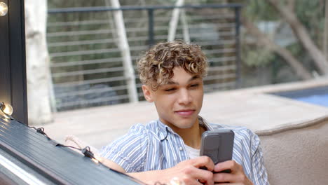 young man relaxing outdoors, using smartphone and enjoying leisure time