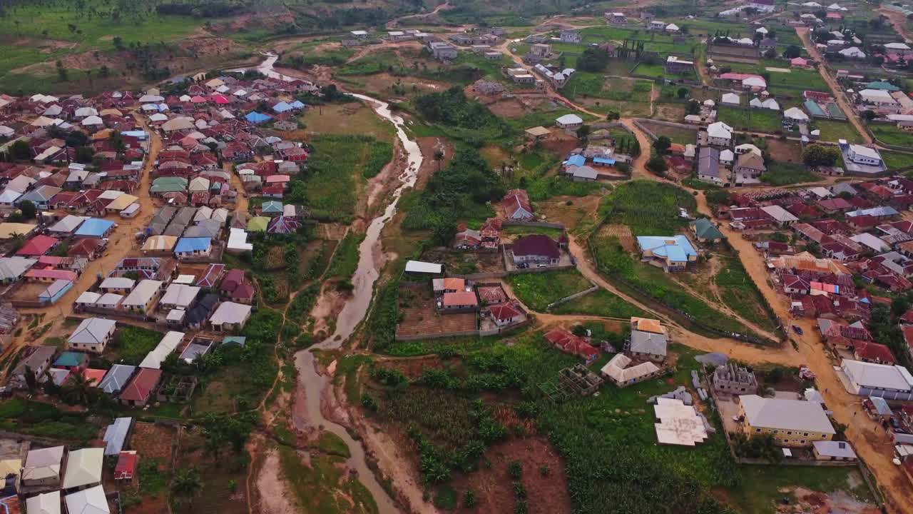 Beautiful aerial tilt up of a creek running through the slums in the outskirts of the town of Kurudu, Nigeria