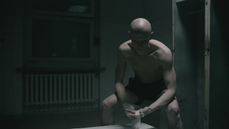 pale bald skinny man badnages his hands in the creepy old bathroom at night