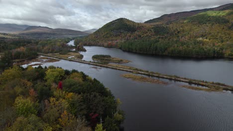 Train-Railway-Surrounded-By-River-And-Rugged-Mountain-Landscape