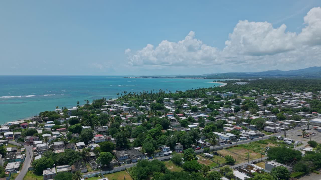 Parallax drone shot of Loiza cityscape with Atlantic Ocean during the day in Puerto Rico, USA
