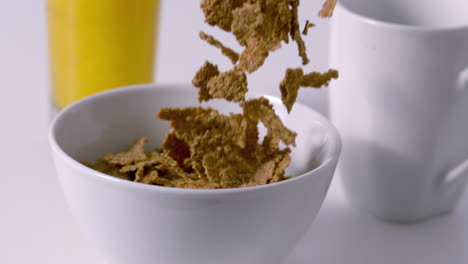 cereal pouring into a bowl at breakfast table