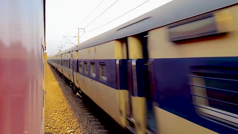 el tren de pasajeros que corre en la vía se cruza entre sí desde la dirección opuesta en la mañana el video se toma en la estación de tren de nueva delhi el 04 de agosto de 2022
