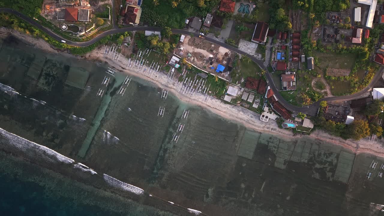 Golden sunset light over a fishing village and coastline on a tropical island, Indonesia