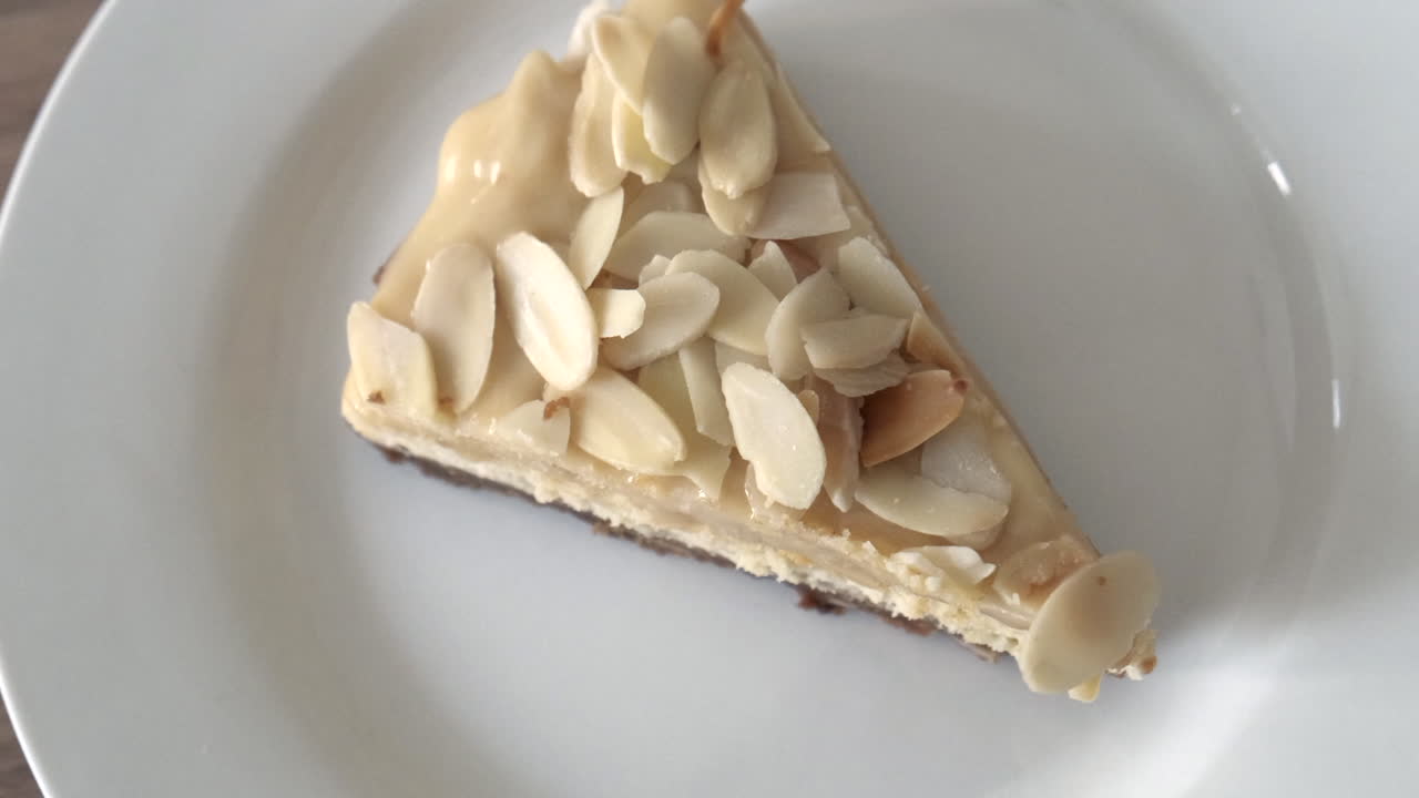 delicioso trozo de tarta de queso con almendras en un plato giratorio