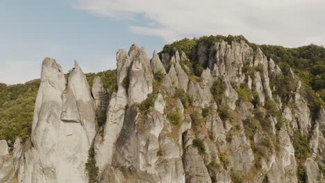 sharp rocks located in slovakia in the the green forest with deciduous trees