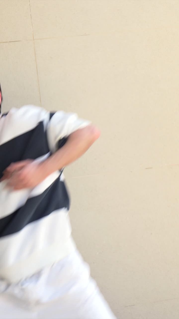 A person wearing a long sleeve sweatshirt and white pants