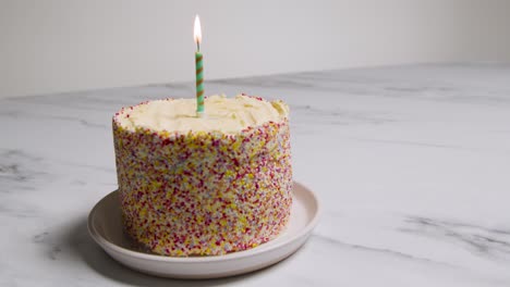 Studio-Shot-Birthday-Cake-Covered-With-Decorations-And-Single-Lit-Candle-2