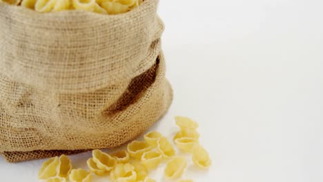 pasta de gnocchi cruda en un saco de hesse sobre un fondo blanco
