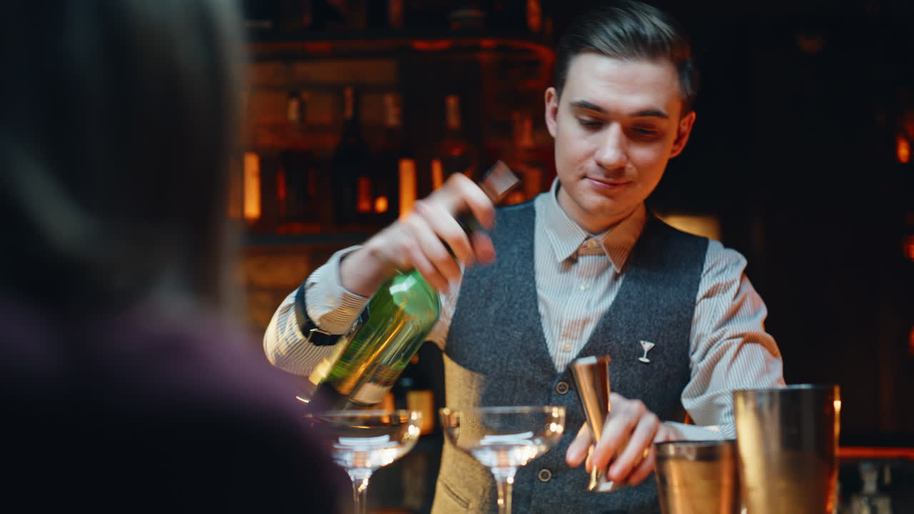 Primo piano di un barista sorridente che serve cocktail al bancone di un bar.