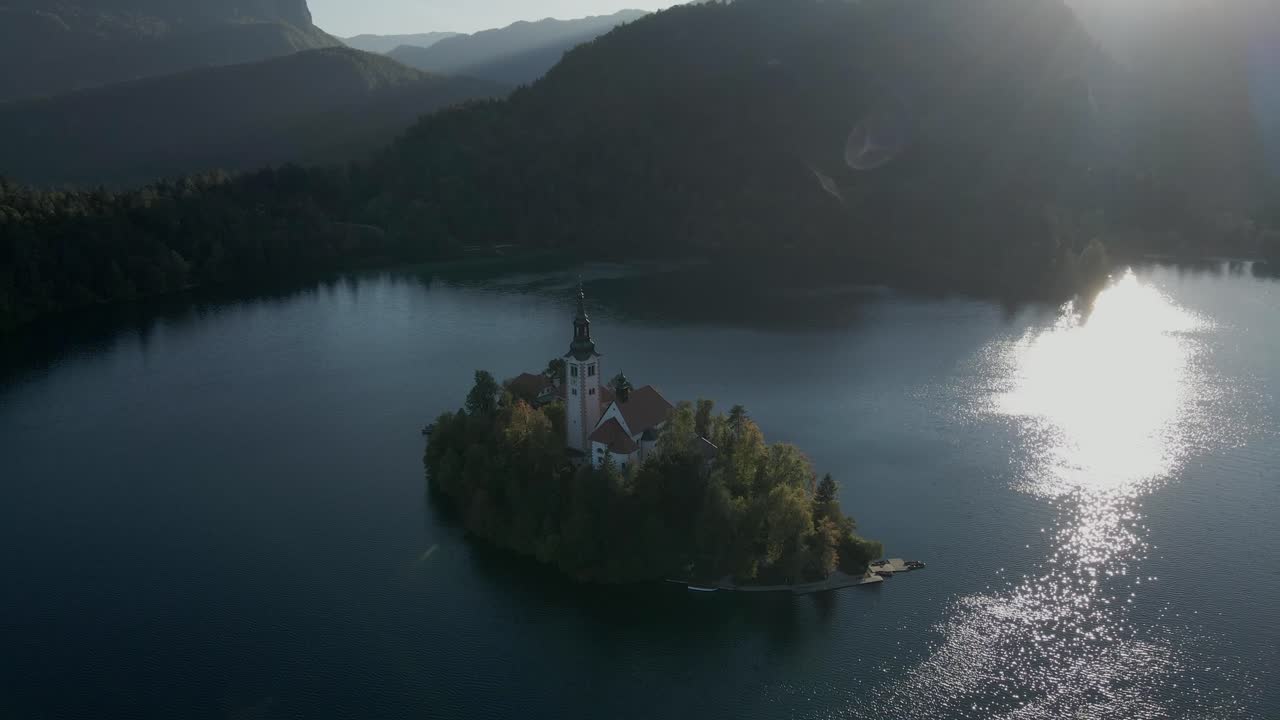 Wschód słońca nad kościołem na wyspie Jeziora Bled z Alpami Julijskimi, Słowenia