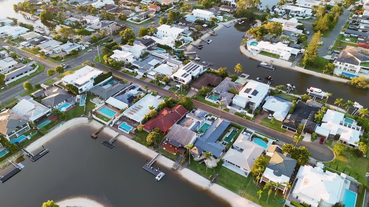 Aerial view of Broadbeach, Gold Coast, showcasing residential homes, pools, and canals under bright daylight