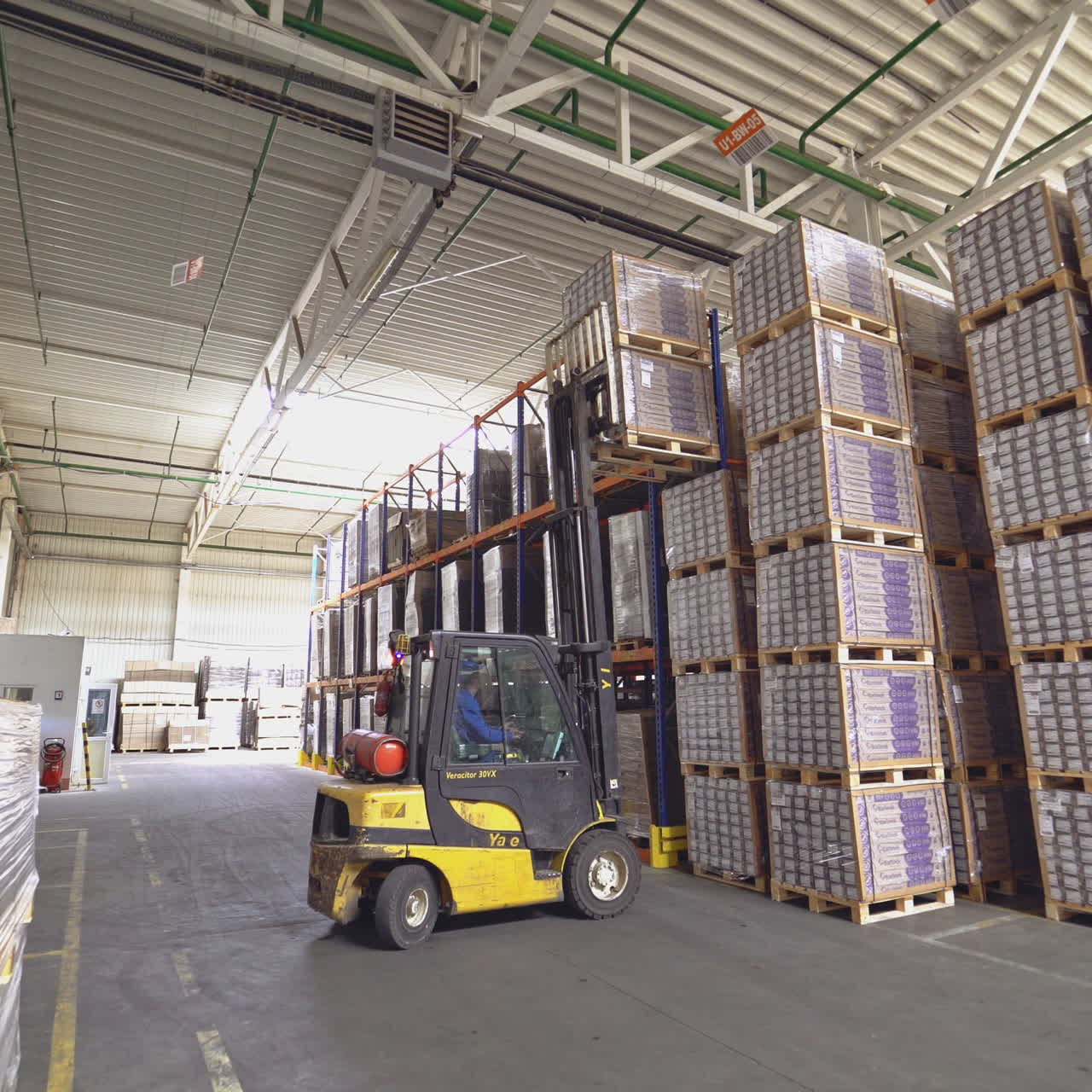 Forklift among the materials in the hangar. Floor and parquet storage.