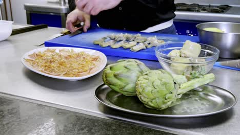 Close-up-of-cooker-cutting-and-preparing-artichokes-in-high-tech-cuisine