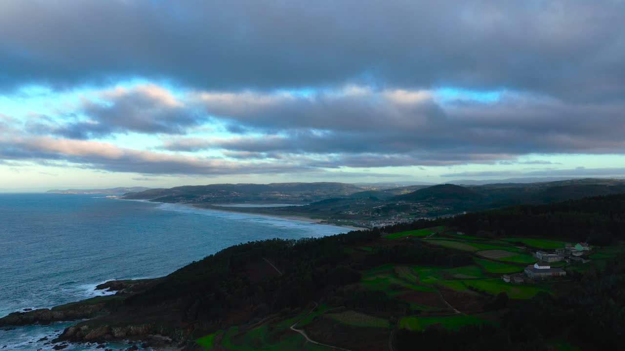 puesta de sol nublada sobre la playa de torradas en el pueblo costero de malpica de bergantinos en una coruña, españa
