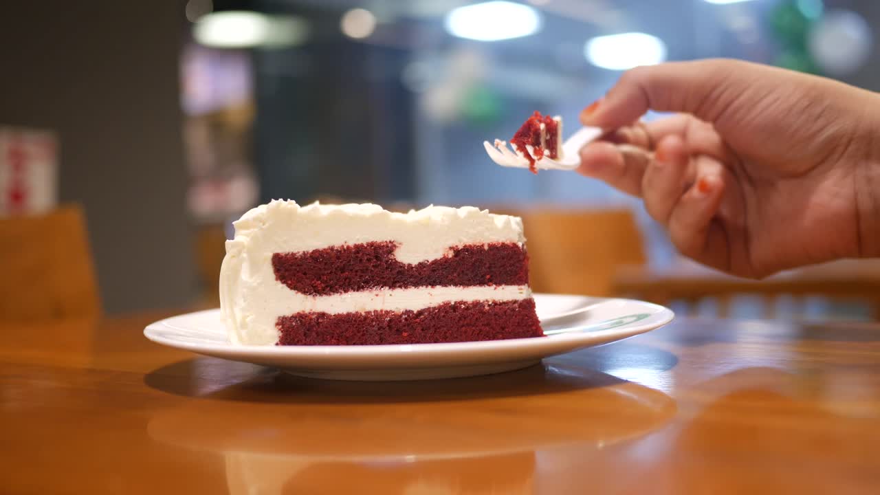 빨간 벨 케이크 조각을 먹고 있다