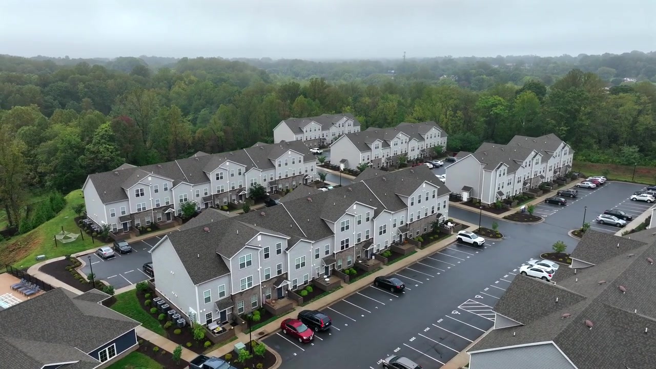 New developed American neighborhood with modern houses and homes in green suburb district of town in Virginia. Rainy and cloudy day in autumn season. Private community swimming pool for population.