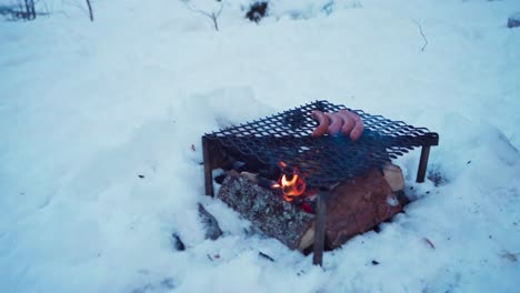 Eine-Person-Kocht-Im-Winter-Draußen-über-Einem-Feuerholz-Mit-Einer-Eisenpfanne
