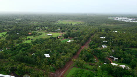 Aerial-drone-of-Rural-Farmland-and-Small-Town-nestled-between-misty-clouds-of-forest-and-dirt-road