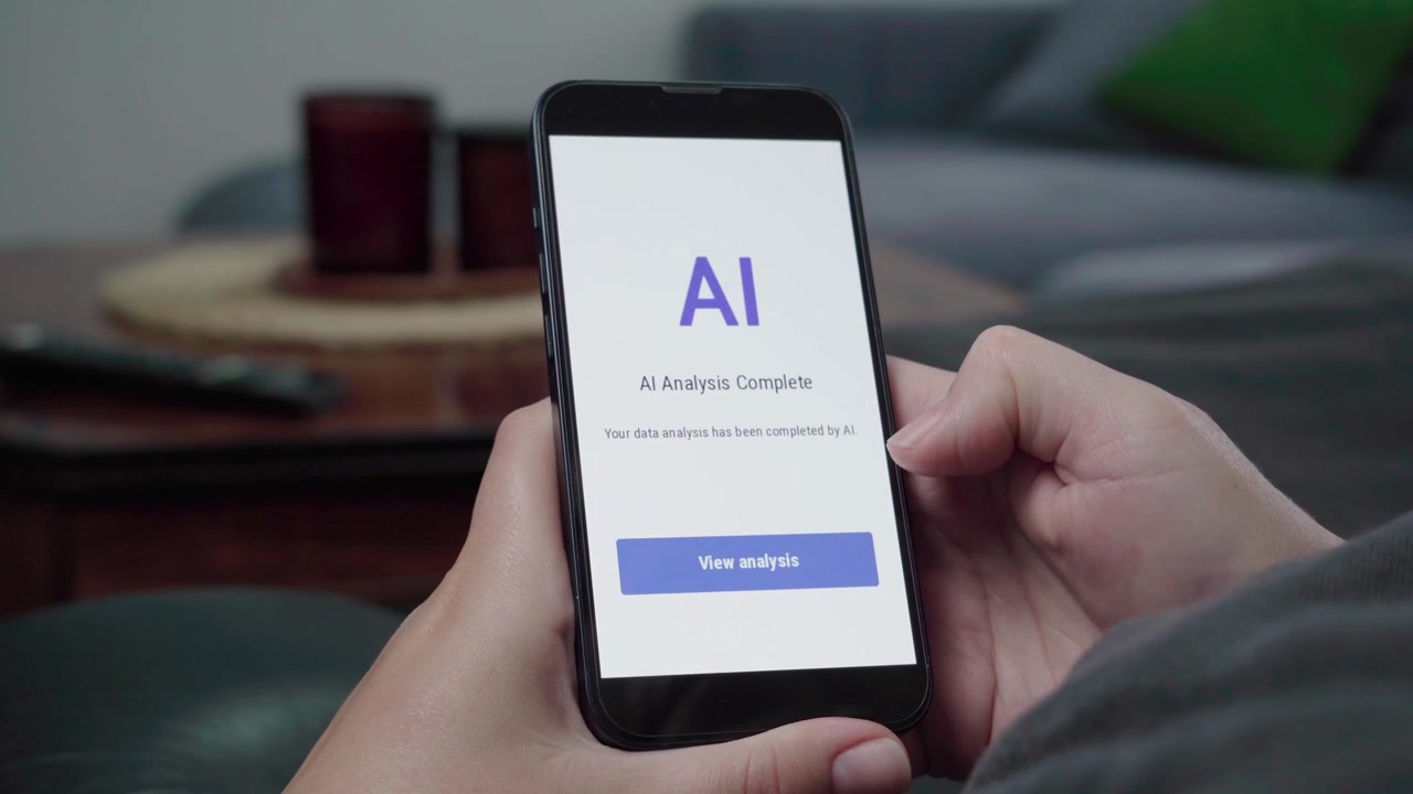 Primo piano di un utente che visualizza un avviso 'Analisi AI Completata' su un'app del telefono con un pulsante blu 'Visualizza analisi' in un ambiente di soggiorno informale