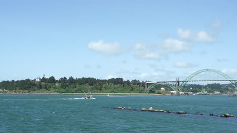 A-fishing-boat-coming-home-from-open-sea-towards-the-Yakina-Bay-Bridge-in-Newport,-Oregon,-USA