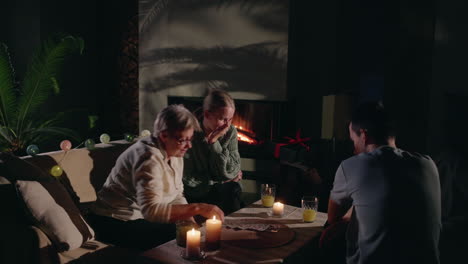 family playing cards by fireplace