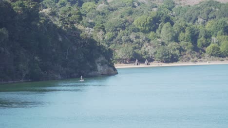 Young-Man-Paddleboarding-on-the-Water-on-a-Calm-Day