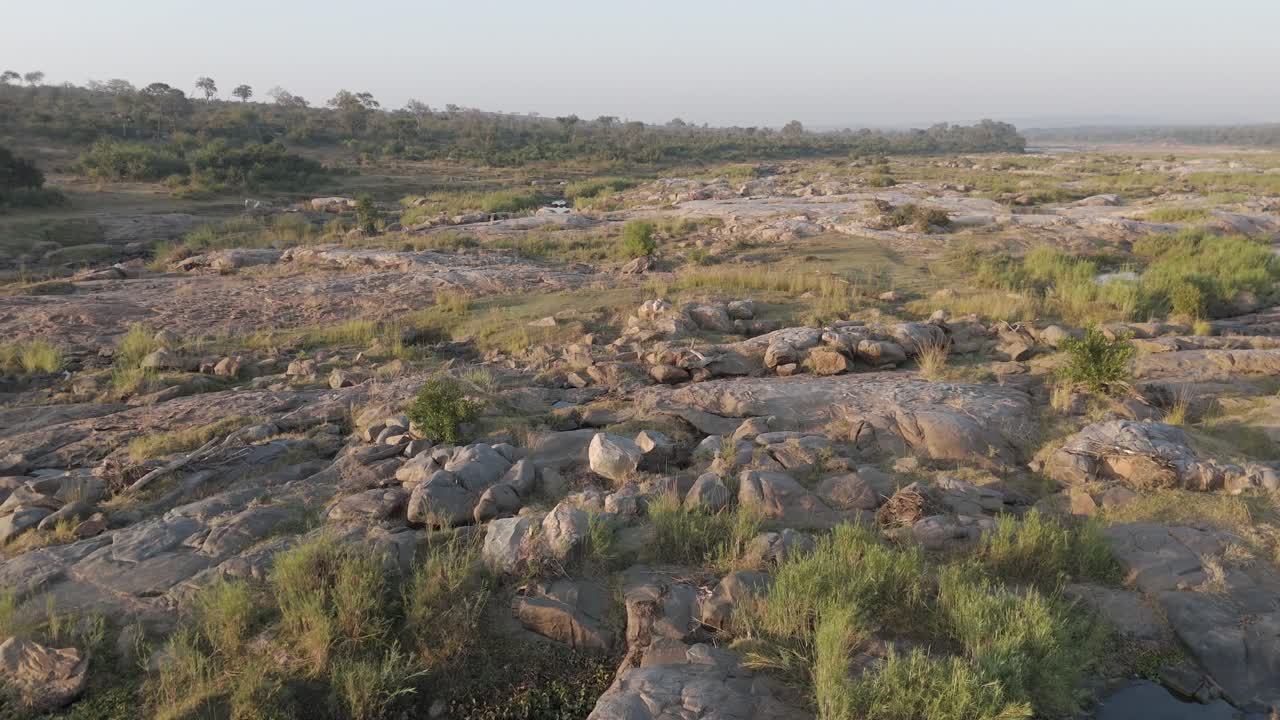 Il paesaggio roccioso del bushveld con un po' d'acqua rimasta da un fiume stagionale