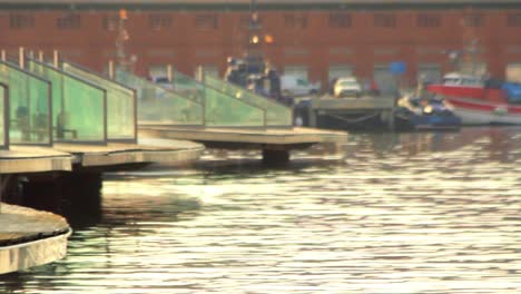 Stone-statues-standing-in-water-at-sea-port-Barcelona-on-background-boat-pier