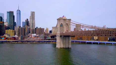 Icónico-Puente-De-Brooklyn,-Bandera-De-Estados-Unidos,-Torre-De-La-Libertad-Pano