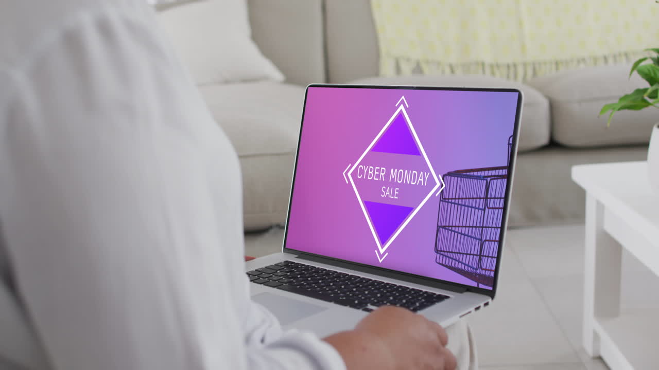 una mujer biracial usando una computadora portátil en casa comprando en línea en el día de venta del lunes cibernético, en cámara lenta