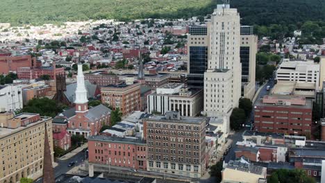 Parallax-effect,-aerial-of-Reading-Pennsylvania-PA-USA-downtown,-aerial-of-American-US-urban-city-setting,-churches,-skyscrapers,-apartments,-traffic-on-summer-day