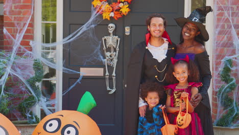 Porträt-Einer-Für-Halloween-Verkleideten-Familie-Vor-Dem-Haus,-Bereit-Für-Süßes-Oder-Saures