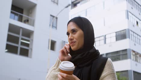 Woman-drinking-coffee-while-talking-on-mobile-phone-4k