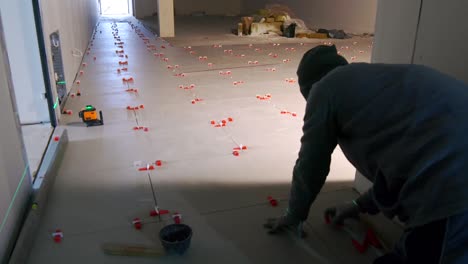 a man is laying ceramic tiles in the hallway