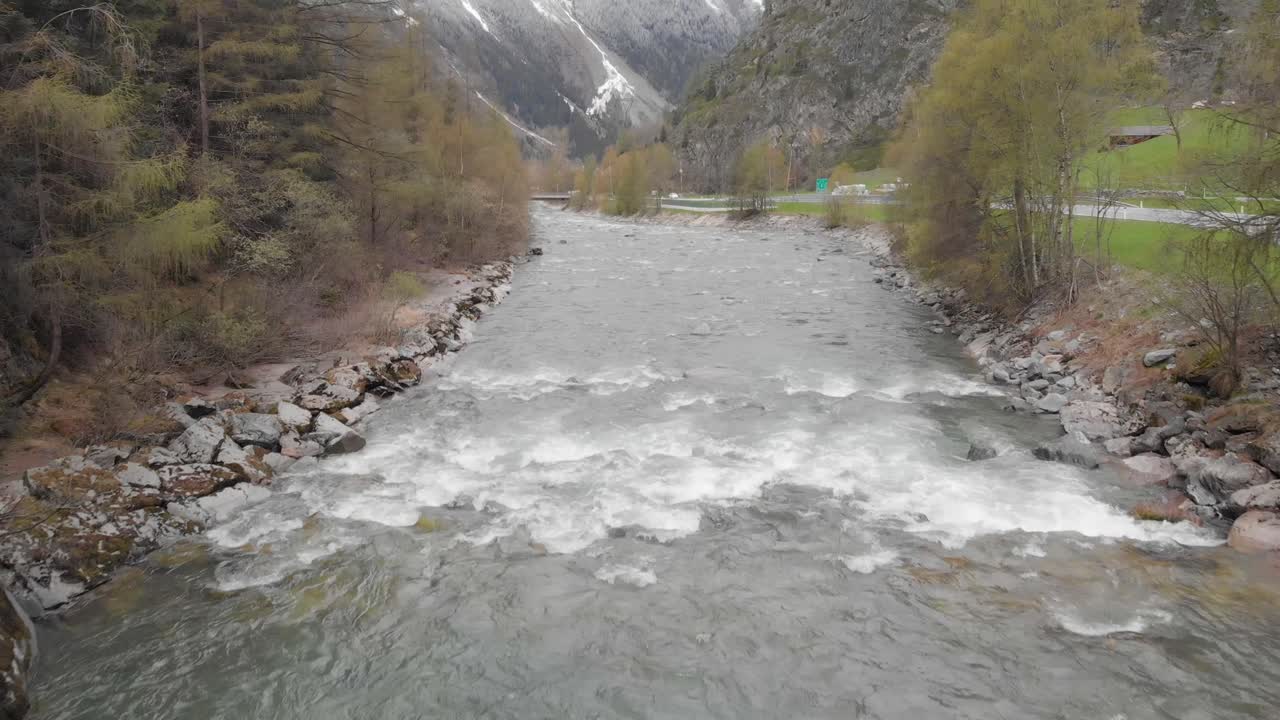 imágenes aéreas de un pequeño pueblo con un río en los alpes austríacos - sölden, austria - drone