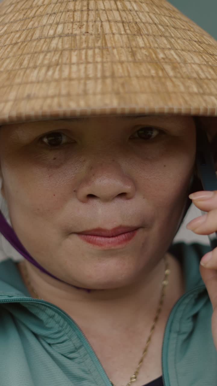 Woman in conical hat talking on phone