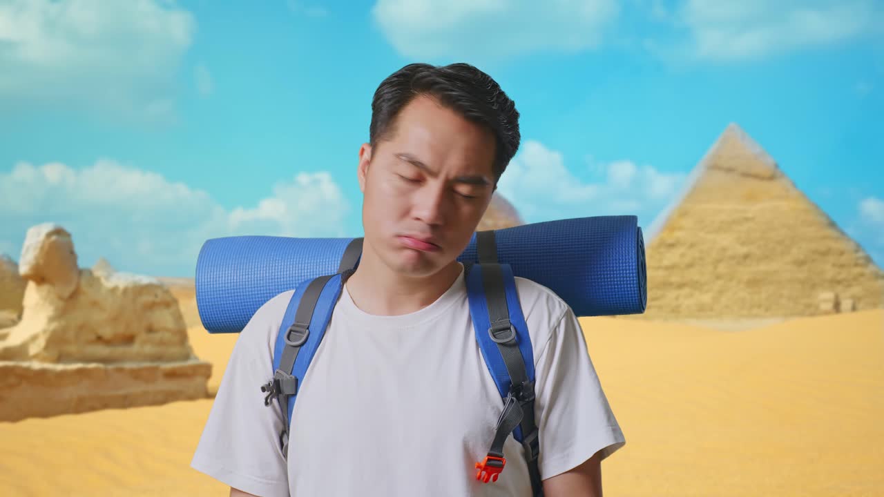 Close Up Of Asian Male Hiker With Mountaineering Backpack Shaking His Head And Making Unsatisfied Face While Traveling In Pyramid Of Giza