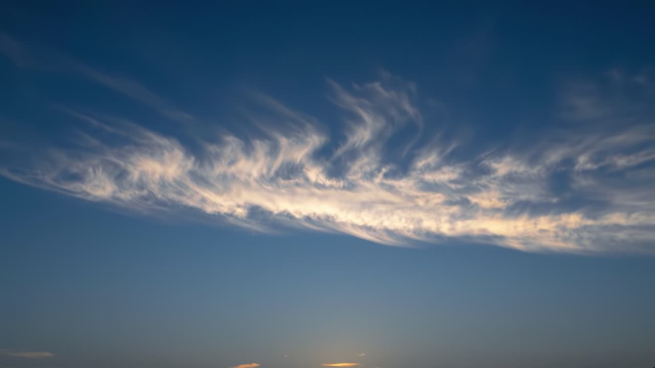 Stunning Transition of a Sunset Sky: Expansive Blue Canvas Adorned with Wispy Clouds and Soft Hues, Capturing the Essence of Evening Serenity and Natural Beauty
