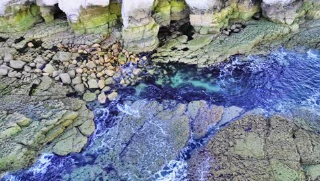 beautiful chalk coastal cliffs at low tide, with visible cracks showing in the cliff faces