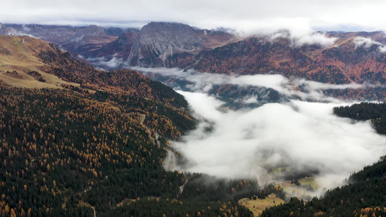 escena aérea en el paisaje montañoso que vuela por encima de las nubes y hacia estructuras rocosas
